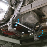 Motorcycle skid plate mounting brackets installed under engine with arrows showing adjustment