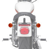 Rear view of motorcycle with orange turn signals, chrome shock absorbers, black seat.
