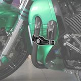 Chrome motorcycle clamp mounted on green engine guard near black engine