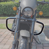 Front view of a motorcycle with chrome crash bars, headlight, and turn signals on a sidewalk