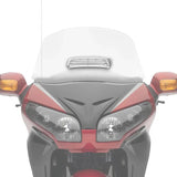 Red motorcycle front with dual headlights and chrome vent on windshield