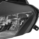 Close-up of a motorcycle headlight assembly with clear lens and black housing