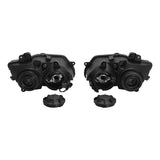 pair of black automotive headlight housings with two circular caps on white background
