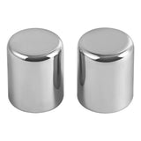 Pair of cylindrical chrome metal caps with polished reflective finish on white background