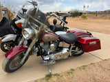 Red and chrome Harley-Davidson motorcycle parked on a driveway beside another touring bike