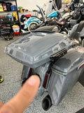 Gray touring motorcycle with saddlebags and top case in a garage workshop