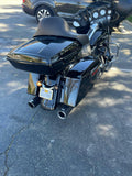 Black touring motorcycle with saddlebags and a large seat parked on asphalt